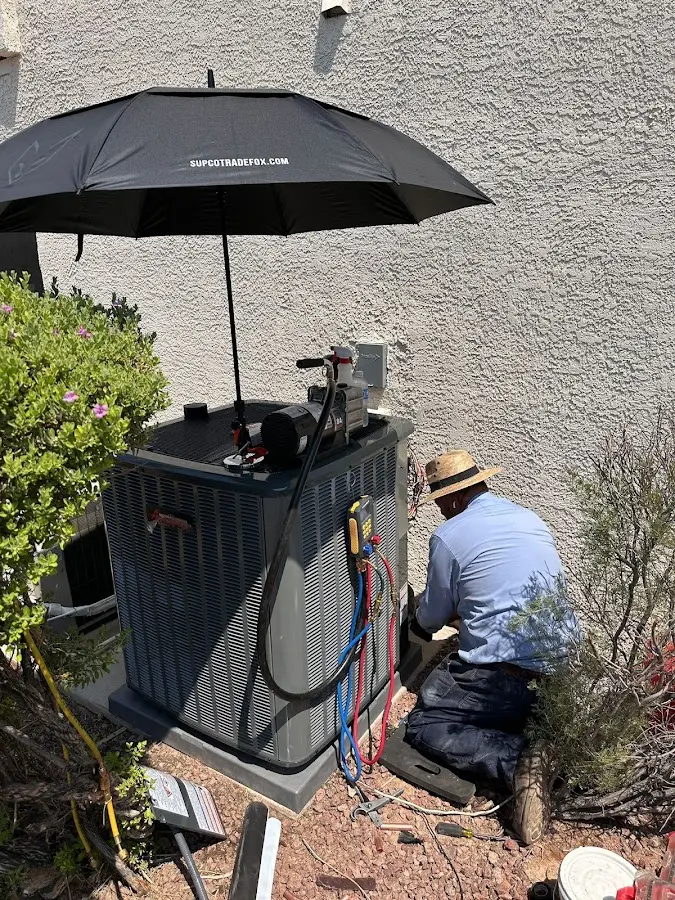 HVAC technician performing outdoor AC maintenance in Laramie