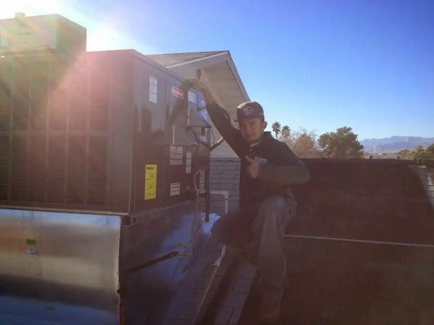 HVAC technician performing Boiler Repair on a rooftop unit in Laramie
